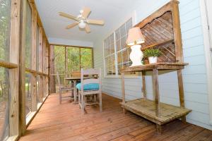 a porch with a table and chairs and a ceiling fan at Porch Lane Cottage C in Fairhope