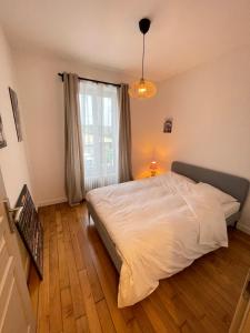 1 dormitorio con cama blanca y ventana en Le Domaine Des Yèbles - Appartement Calme et élégant, en Avon