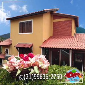 a house with a bunch of flowers in front of it at Pousada Chalé na Roça Penedo in Penedo