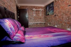 a bed in a room with a brick wall at Mini cinema & movie studio with PS5 in Riga