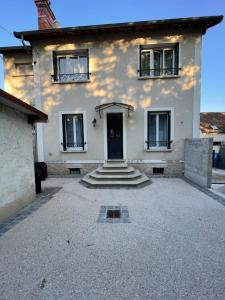 una casa blanca con una puerta y escaleras delante en Le Domaine Des Yèbles - Appartement Calme et élégant, en Avon