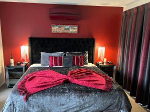 a bedroom with a large bed with a red wall at Kaiteriteri Retreat in Kaiteriteri