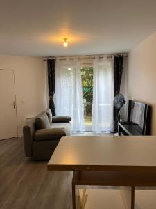 ein Wohnzimmer mit einem Sofa und einem TV in der Unterkunft Moderne & LUXURY T2 Paris la défense in Puteaux