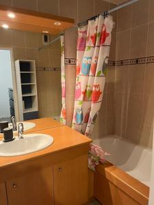 a bathroom with a sink and a tub and a shower curtain at Moderne & LUXURY T2 Paris la défense in Puteaux