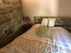 um quarto com uma cama com uma almofada em LE CHALET de la goutte em Saint-Appolinaire