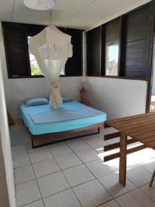 - une chambre avec un lit doté d'une moustiquaire dans l'établissement Tikoté Chwit point 0, à Cayenne