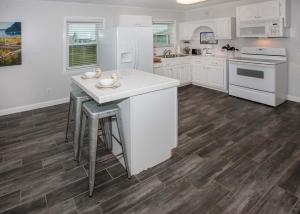 a kitchen with white appliances and wooden floors at Breaking Even House in Fort Morgan