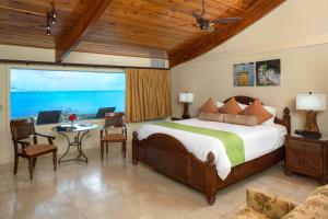a bedroom with a bed and a view of the ocean at The Buccaneer Beach & Golf Resort in Christiansted