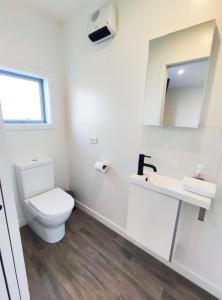 a white bathroom with a toilet and a sink at Antair Lakeview Lodge in Lake Tekapo