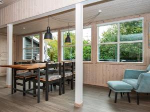 a dining room with a table and chairs and windows at 6 person holiday home in Struer-By Traum in Struer
