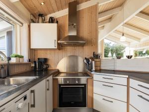 8 person holiday home in Otterup في Otterup: مطبخ مع مغسلة وموقد