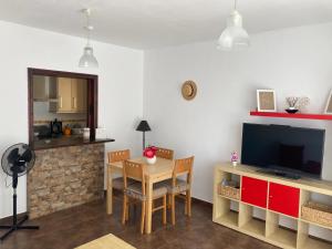a living room with a television and a table and chairs at Apartamento Las Chumberas in Roquetas de Mar +44 photos