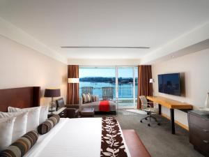 a hotel room with a bed and a desk at Inn at Laurel Point in Victoria