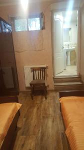 a room with two beds and a chair and a sink at Apartment in the city center in Tbilisi City