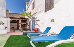 two blue chairs sitting on the grass in a yard at Stunning Home In Padul With Kitchen in Padul