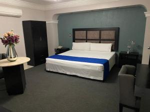 a bedroom with a large bed with a blue wall at Hotel Real de La Barca in La Barca +59 photos