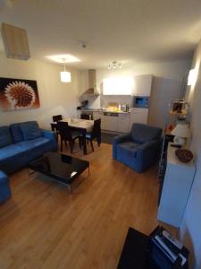 sala de estar con sofá azul y mesa en Kerstin 5 by SMR Rauris Apartments - inc Spa and National Summercard - near Gondola, en Rauris