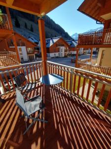 a table and a chair on a deck at Kerstin 5 by SMR Rauris Apartments - inc Spa and National Summercard - near Gondola in Rauris