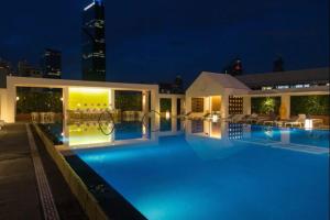 een groot zwembad 's nachts met een gebouw bij Yoo Panama in Panama-Stad