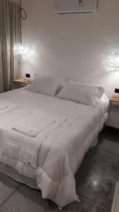 a white bed with white sheets and pillows at Flamencos Rosados in José Ignacio