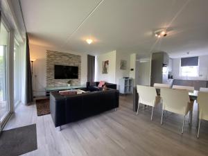 sala de estar con sofá negro y mesa en Villa Christina, en Stevensweert