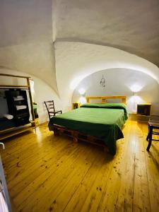 Un dormitorio con una cama verde en un ático en Antony’s Home, en Catania