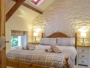 a bedroom with a bed with pillows on it at Guildford Bridge Cottage in Llangwm