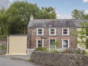 une maison en briques avec un garage en face de celle-ci dans l'établissement Guildford Bridge Cottage, à Llangwm