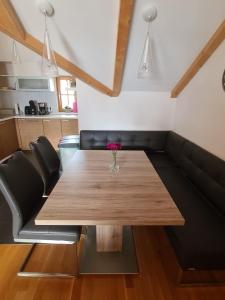 une salle à manger avec une table en bois et un canapé noir dans l'établissement Daniela 7 by SMR Luxury Apartments, à Rauris
