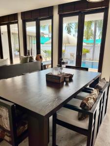 - une salle à manger avec une table et un canapé dans l'établissement Villa Nirwana - Jasmin 3BR with private pool, à Ban Ang Thong