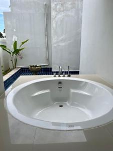 La salle de bains est pourvue d'une grande baignoire blanche et d'une fenêtre. dans l'établissement Villa Nirwana - Jasmin 3BR with private pool, à Ban Ang Thong
