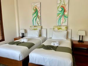 - 2 lits dans une chambre d'hôtel ornée de fleurs dans l'établissement Villa Nirwana - Jasmin 3BR with private pool, à Ban Ang Thong