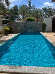 a swimming pool with blue water in front of a house at Villa Nirwana - Jasmin 3BR with private pool in Ban Ang Thong