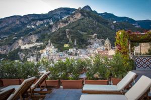 a balcony with chairs and a view of a city at Hotel Marina Riviera in Amalfi