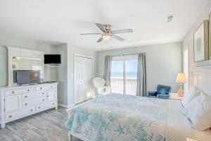 a bedroom with a bed and a television and a window at Avalon Topsail Beach in Topsail Beach