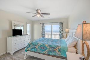 a bedroom with a bed and a television and a window at Avalon Topsail Beach in Topsail Beach