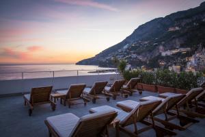 a group of chairs and tables on a balcony with the ocean at Hotel Marina Riviera in Amalfi