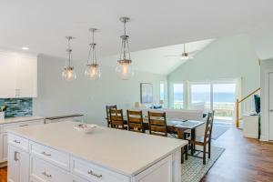 uma cozinha e sala de jantar com mesa e cadeiras em Slow Your Roll em Topsail Beach