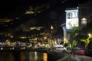 a view of a city at night with a river at Hotel Marina Riviera in Amalfi