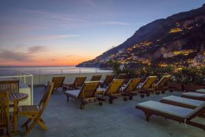 a group of chairs sitting on a balcony overlooking the ocean at Hotel Marina Riviera in Amalfi