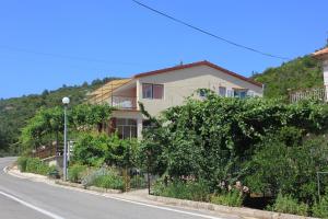 ein Gebäude an der Seite einer Straße mit Bäumen in der Unterkunft Apartments by the sea Zaglav, Dugi otok - 8145 in Zaglav