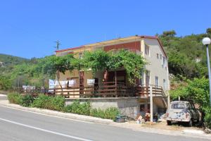 a house on the side of the road with a car parked in front at Apartments by the sea Zaglav, Dugi otok - 8145 in Zaglav