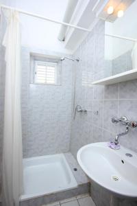 ein Badezimmer mit einer weißen Badewanne und einem Waschbecken in der Unterkunft Apartments by the sea Zaglav, Dugi otok - 8145 in Zaglav