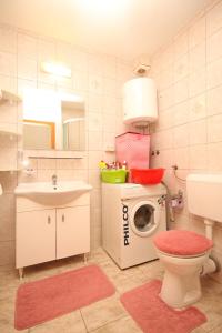 W łazience znajduje się toaleta, umywalka i pralka. w obiekcie Apartments by the sea Razanj, Rogoznica - 8361 w Rogoznicy