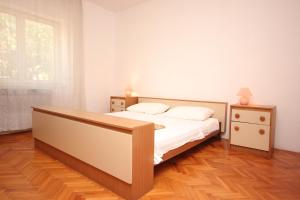 ein Schlafzimmer mit einem Bett, zwei Nachttischen und einem Fenster in der Unterkunft Apartments by the sea Zaglav, Dugi otok - 8146 in Zaglav