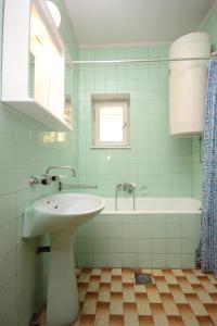 ein Badezimmer mit einem Waschbecken und einer Badewanne in der Unterkunft Apartments by the sea Zaglav, Dugi otok - 8146 in Zaglav