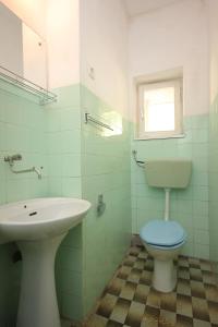 ein Bad mit einem Waschbecken, einem WC und einem Fenster in der Unterkunft Apartments by the sea Zaglav, Dugi otok - 8146 in Zaglav