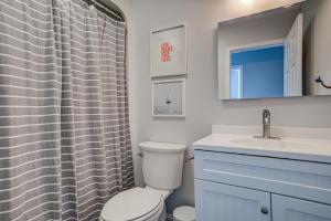a bathroom with a toilet and a sink at Light Oasis in Topsail Beach +18 photos