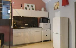 a kitchen with white cabinets and a refrigerator at 1 Bedroom Gorgeous Home In Basbellain in Basbellain