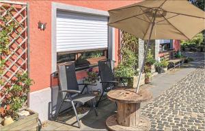 una mesa y sillas con una sombrilla en el patio en 1 Bedroom Gorgeous Home In Basbellain en Basbellain
